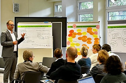 Blick aus den Teilnehmerreihen auf Dr. Philipp Polenz, der die Ergebnisse seines Clusters vorstellt.